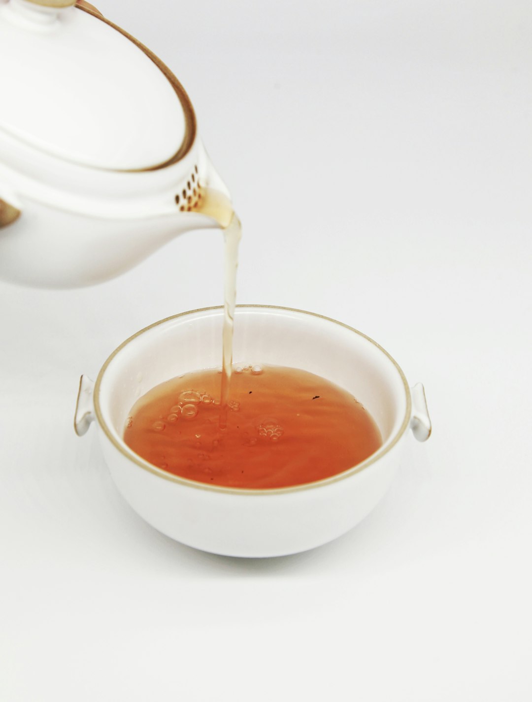 tea pours into white teacup