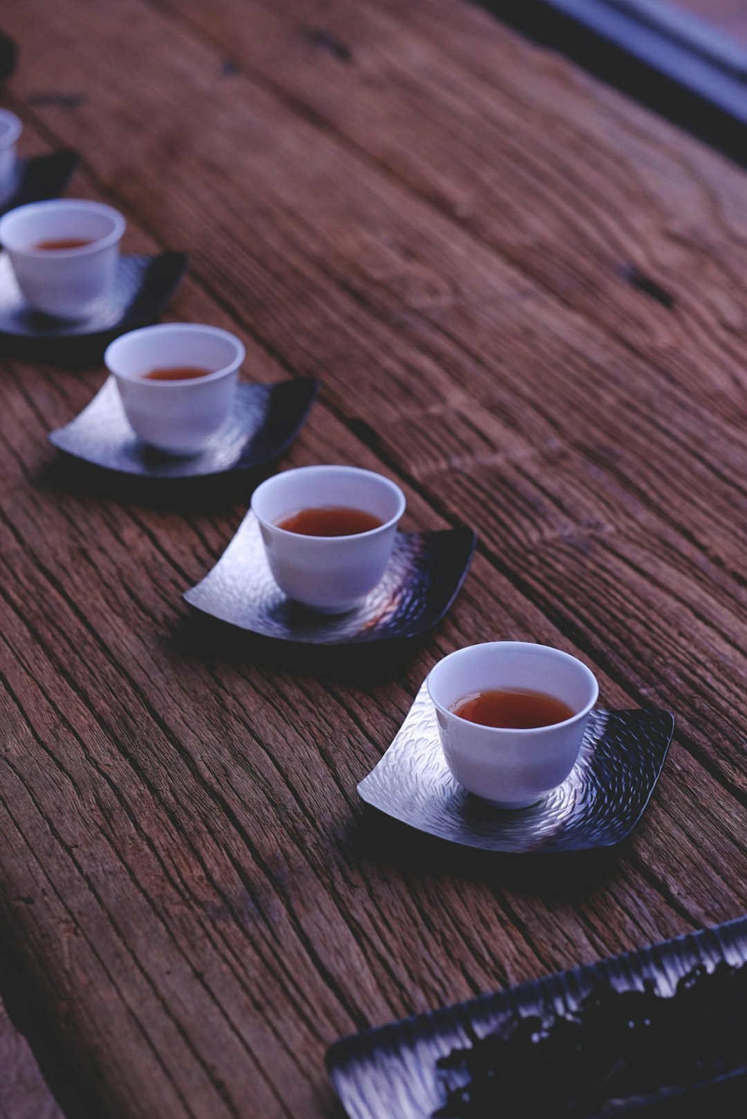 inline white ceramic bowls filled with brown liquids on brown wooden table