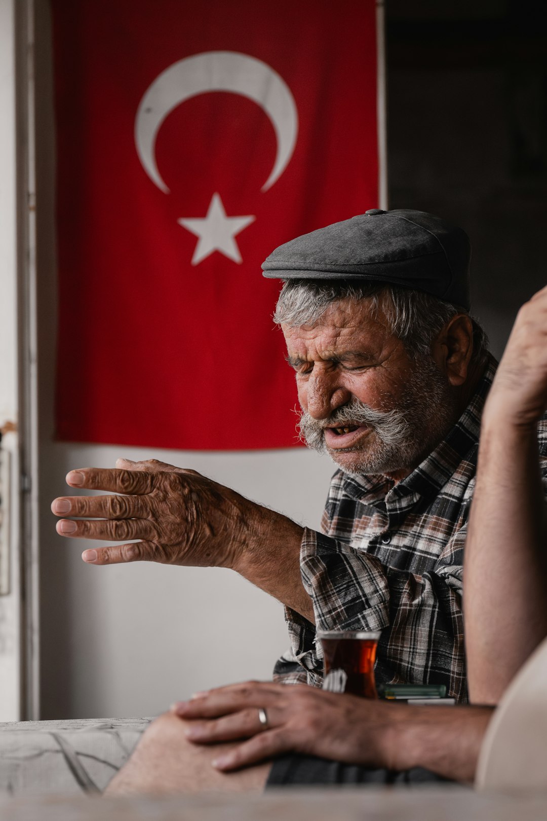 A man sitting at a table in front of a flag