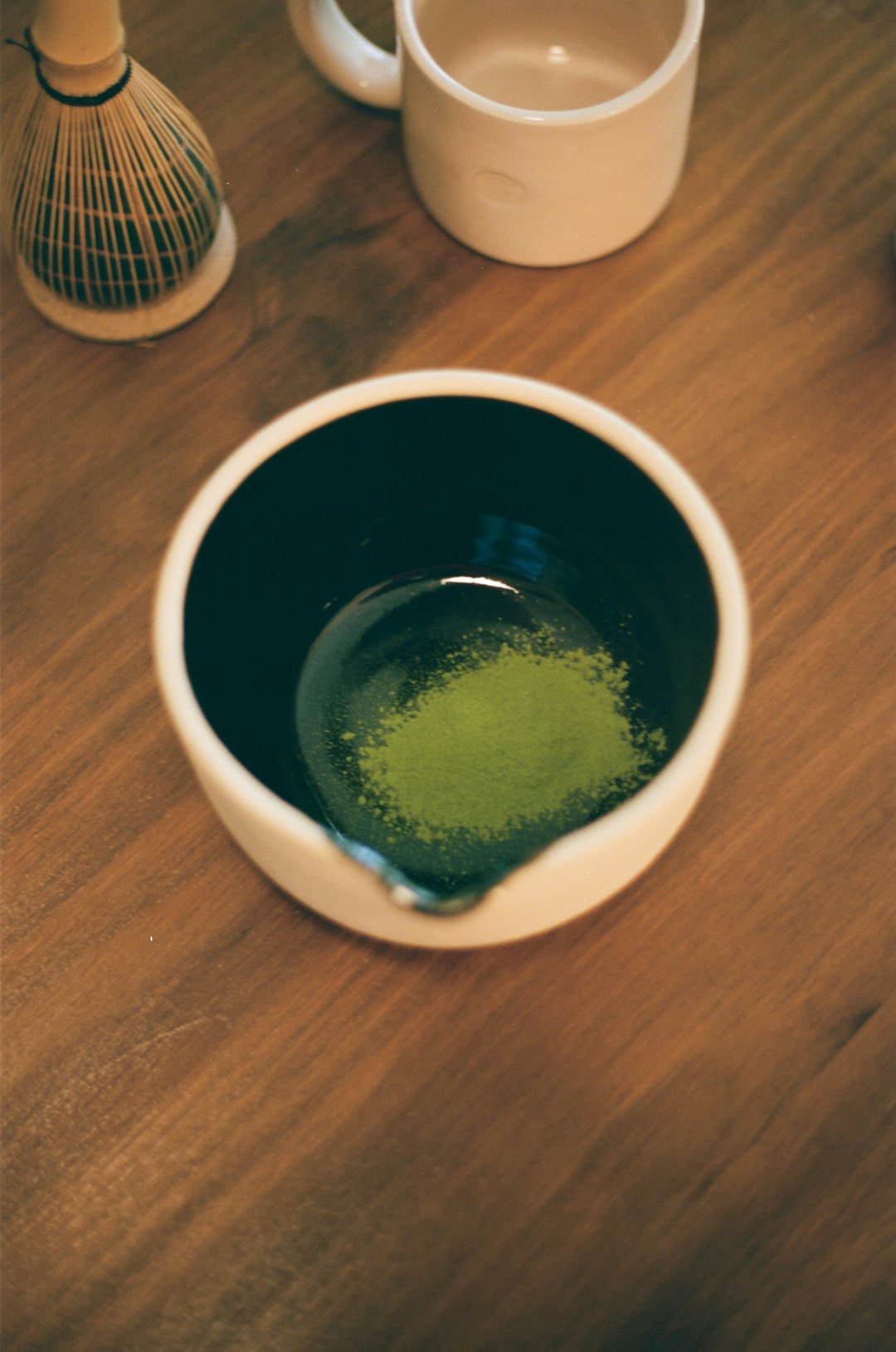 Matcha tea powder in a bowl, ready to be whisked.