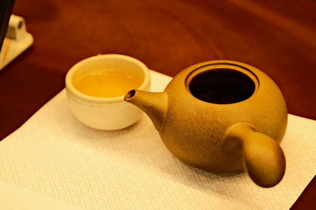 Tea is served in a cup next to a teapot.