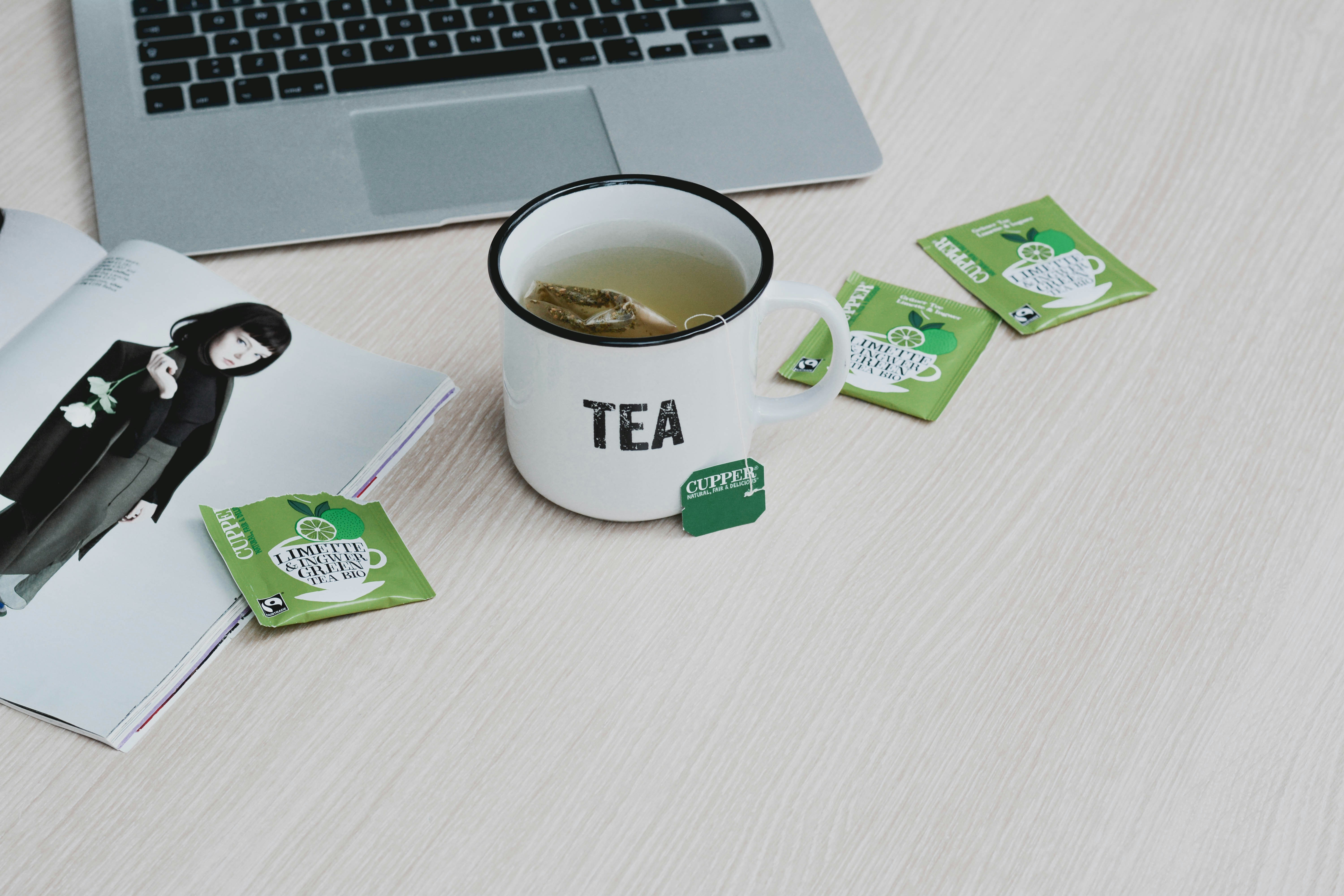 white ceramic mug beside green and white box